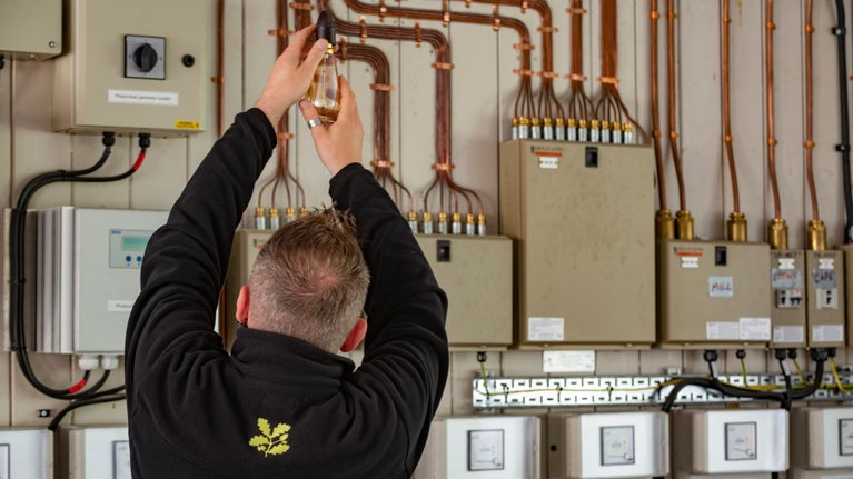 National Trust staff member adjusting pipes on the green energy system at Hardcastle Crags, Yorkshire
